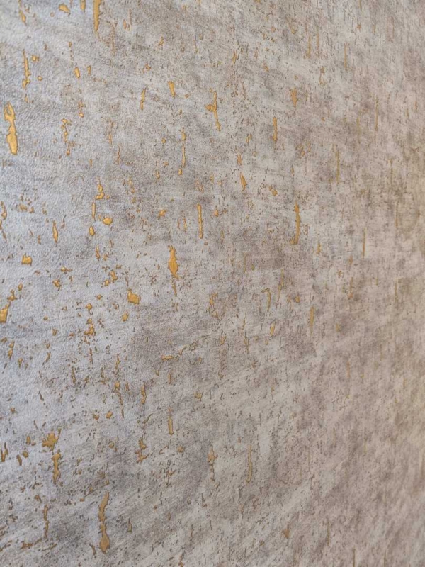 Detailansicht einer goldfarbenen Wandtapete mit abstraktem Design.