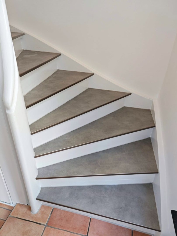 Weiße Treppe mit grauen Stufen und weißem Geländer
